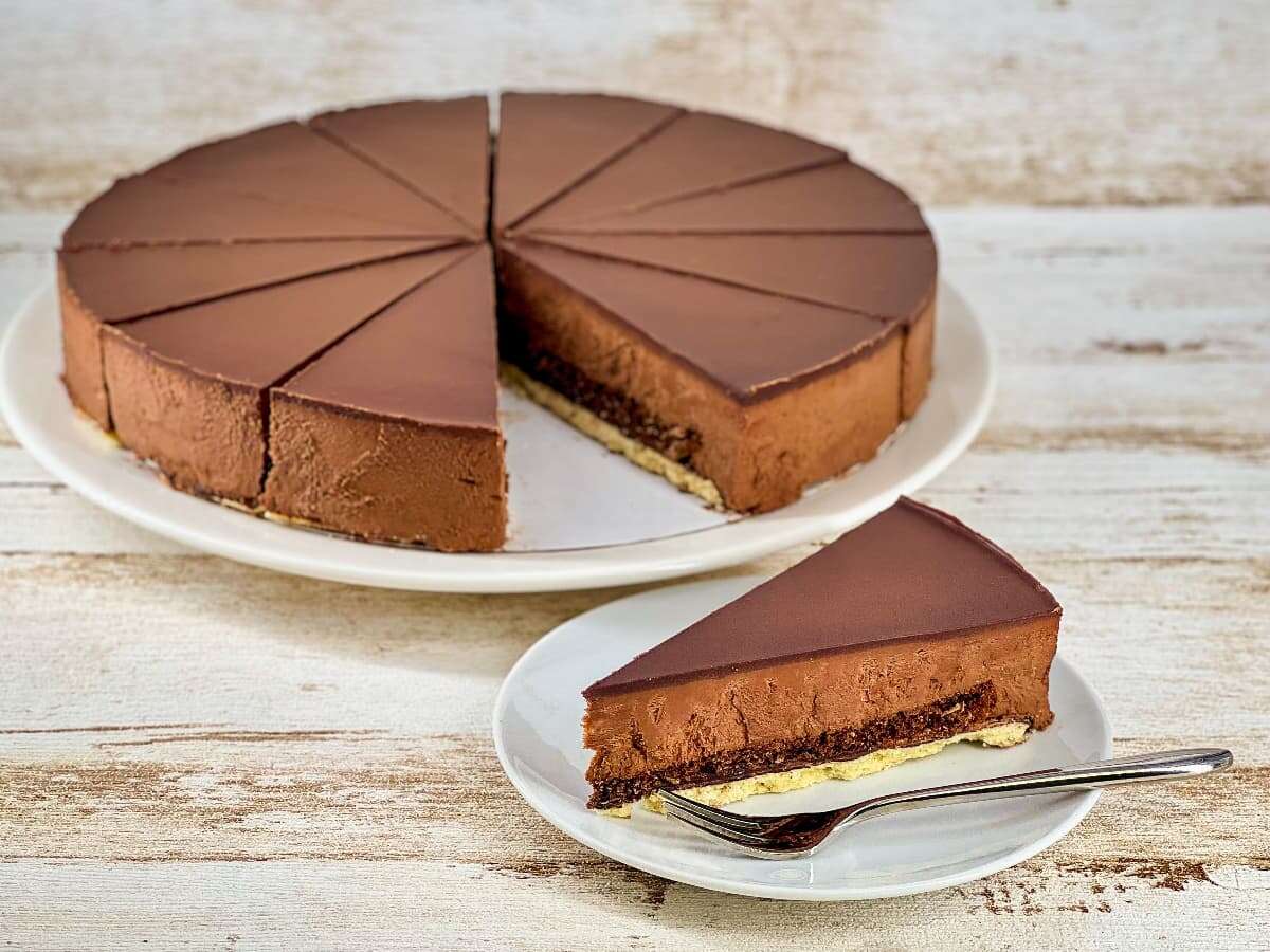 Grote chocolade truffeltaart met een losse punt ernaast op een schoteltje