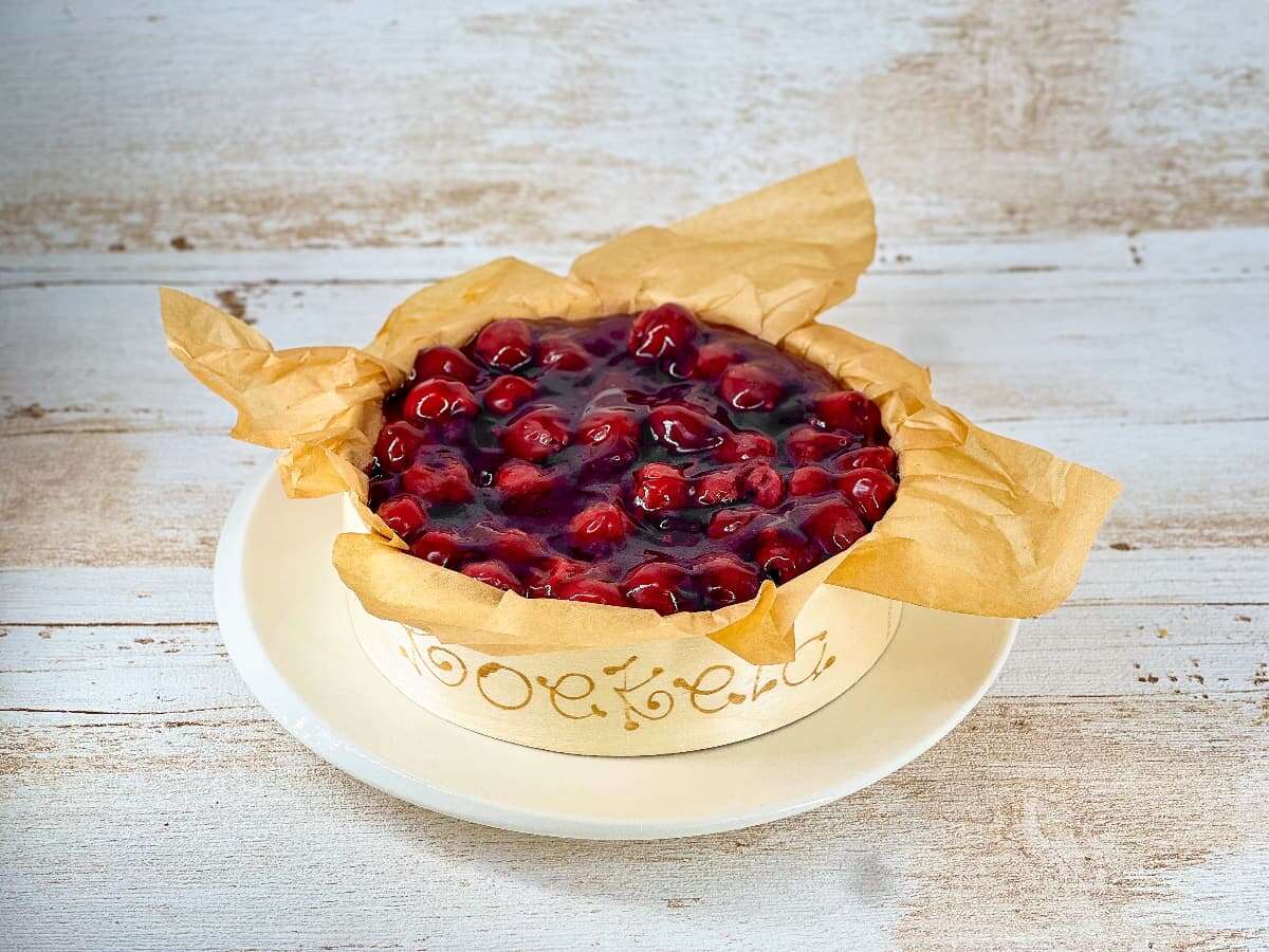 Kleine kersen cheesecake in houten ring met Koekela logo